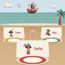 Porte-prénoms pirates à imprimer, pliés et posés sur la table de fête devant les assiettes, au prénom de chaque invité(e)