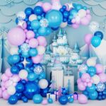Arche de ballons bleus, roses et blancs dressée devant un château enneigé et ses cadeaux
