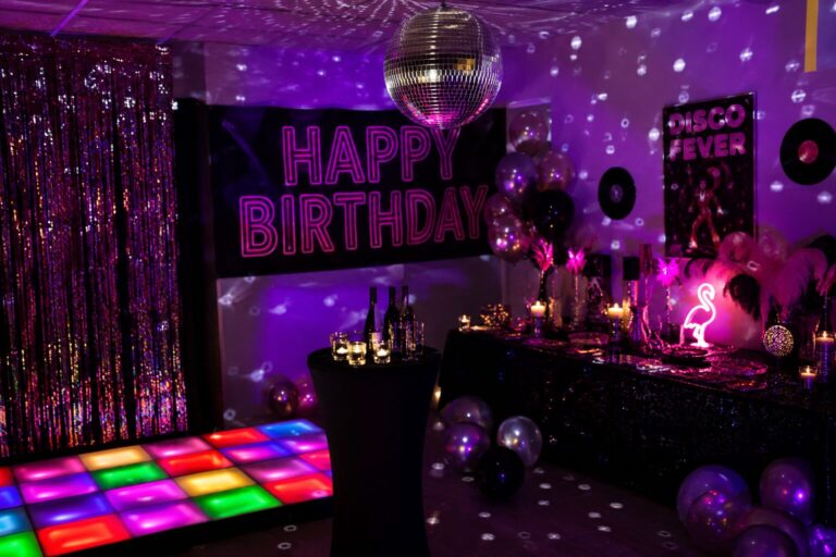 Salle d'anniversaire disco : boule à facettes, banderole Happy Birthday et piste de danse lumineuse