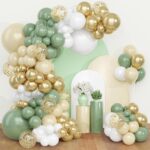 Arche de ballons vert sauge, beige, blancs et dorés à confettis devant des panneaux arrondis et fleurs blanches