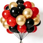 Bouquet de ballons de baudruche rouges, noirs et dorés pour une décoration d'anniversaire pirate