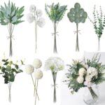 Fleurs artificielles blanches et feuillages d'eucalyptus assemblés en bouquet dans un vase transparent