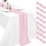 Chemin de table en gaze de coton rose poudré déroulé sur une table de mariage dressée en blanc