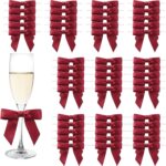 Petits nœuds en satin bordeaux à clipser sur les flûtes à champagne d'un mariage