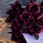 Bouquet de roses artificielles bordeaux posé sur un plateau doré, ambiance mariage sombre et chic