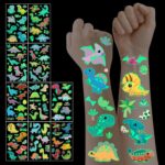 Tatouages éphémères dinosaures phosphorescents appliqués sur le bras d'un enfant, brillants dans le noir