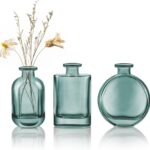 Trois vases en verre bleu vert garnis de fleurs séchées, décor de mariage bord de mer