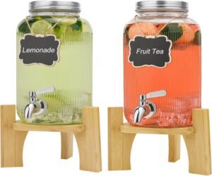 Deux fontaines à boissons en verre sur support en bois, citronnade et thé aux fruits pour servir les invités
