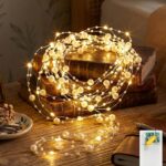 Guirlande lumineuse à perles nacrées posée sur des livres pour une décoration de crémaillère chaleureuse