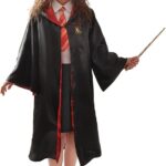 Fillette en déguisement d'Hermione, robe de sorcière noire de Gryffondor et baguette en main, pour le coin photo de la fête