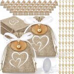 Sachets en jute imprimés de cœurs blancs avec ruban satiné et breloques cœur dorées, pour les dragées d'un baptême