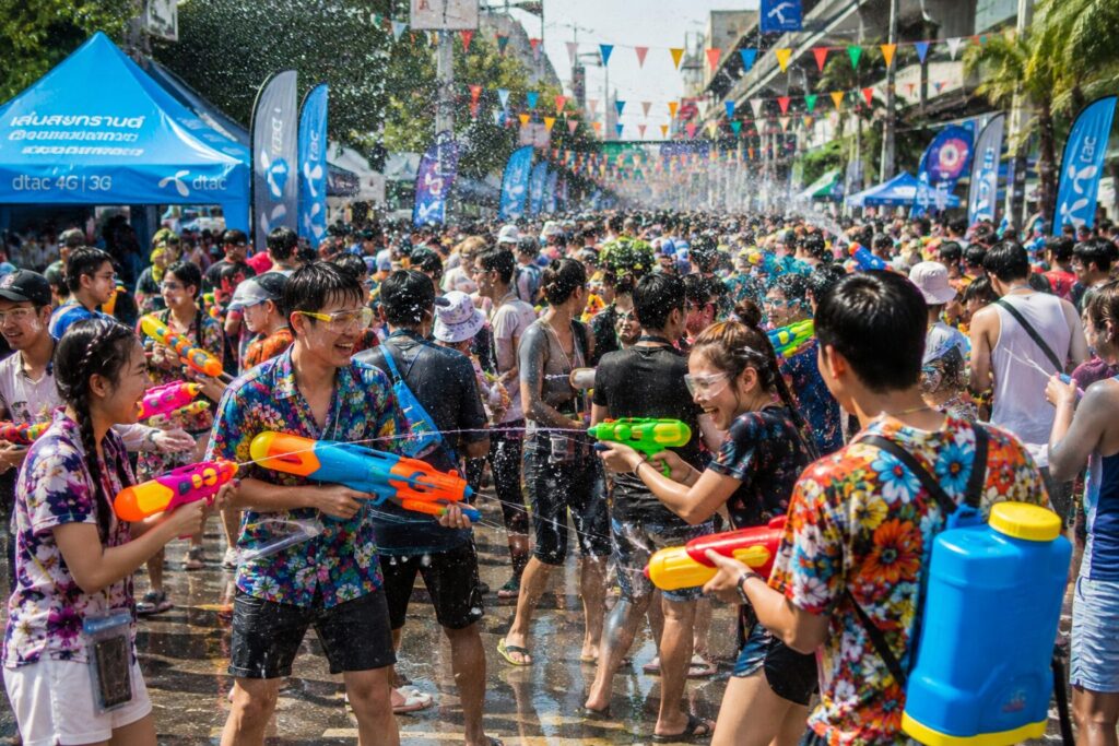 Rue animée de Thaïlande pendant Songkran : jeunes armés de pistolets à eau en pleine bataille d'eau géante
