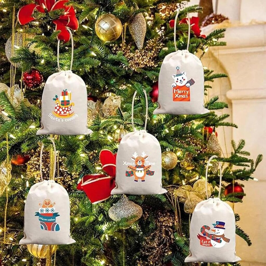 Pochons en tissu blanc à motifs de Noël suspendus dans un sapin décoré, idée de calendrier de l'Avent réutilisable